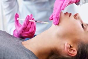Picture of young woman gets kybella chin injection in beauty salon