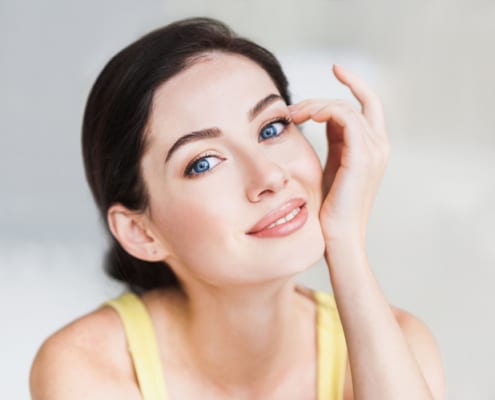 Young woman touching her face