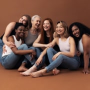 Portrait of six laughing women of different ages and body types sitting together